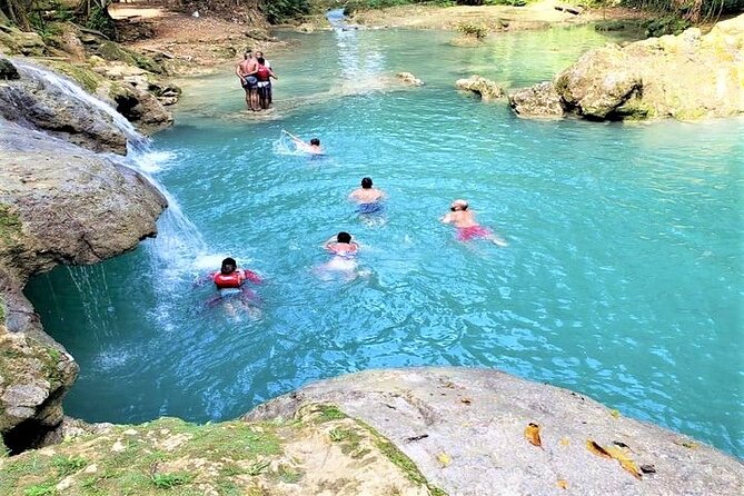 Blue Hole & Secret Falls Day-Trip with Shopping from Grand Palladium - Entering Cool Blue Hole’s bright mineral pools